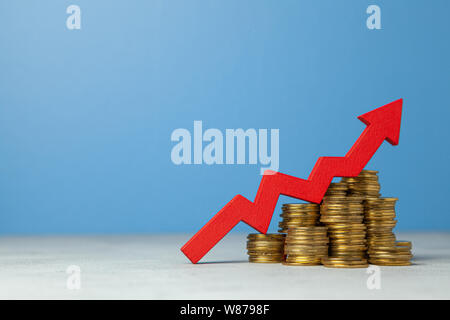Pfeil nach oben und Stapel von Münzen. Das Konzept der Anhebung der Steuern oder die Steigerung der Gewinne im Geschäft. Stockfoto
