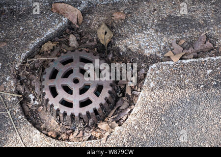 Nahaufnahme des alten Metallgitter auf das Ablassrohr in der Nähe der Weg in den städtischen Park. Stockfoto