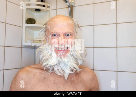 Gerne älterer bärtiger Mann Duschen Stockfoto
