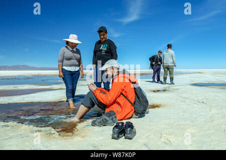 Uyuni Salzsee, Uyuni, Bolivien: Touristen zu Fuß in der Weißen salar und Jeep Tour Aktivitäten durch die bolivianischen Salzwüste fahren genießen Stockfoto