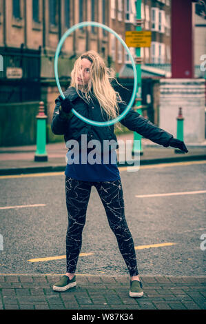 Mädchen sucht in einer Spinnerei Hoop, volle Länge Körper darstellen, in der Straße der Stadt. Kopieren Sie Platz. Stockfoto