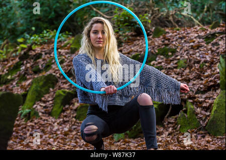 Mädchen schaut direkt in die Kamera, geduckt, heraus halten, einen Reifen vor ihr, im Wald Posing, kopieren. Stockfoto