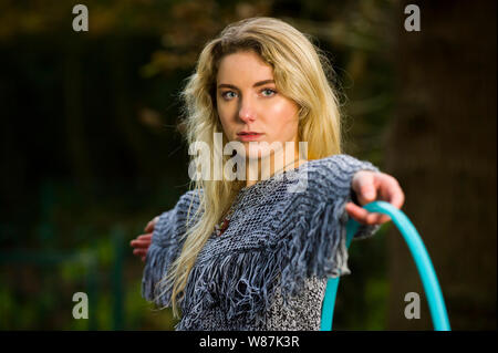 Mädchen schaut direkt in die Kamera, heraus halten, einen Reifen auf die Kamera in den ausgestreckten Arm, in Wäldern Posing, kopieren. Stockfoto