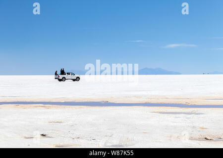 Uyuni Salzsee, Uyuni, Bolivien: Touristen zu Fuß in der Weißen salar und Jeep Tour Aktivitäten durch die bolivianischen Salzwüste fahren genießen