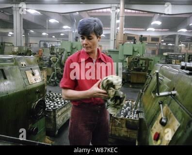 01. Januar 1990, Berlin, Brandenburg: DDR/Brandenburg/Industrie/Dezember 1989 Getriebewerk Brandenburg, Halle. Die Anlage produziert Getriebe für Nutzfahrzeuge. Die Fabrik war veraltet, die Arbeitsbedingungen waren schlecht. Frau an der Drehbank. Beste Bildqualität, genaue Aufnahmedatum nicht bekannt. Foto: Paul Glaser/dpa-Zentralbild/ZB Stockfoto