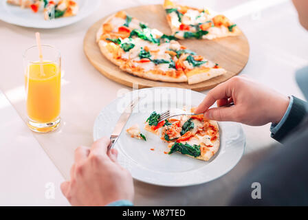 Junger Mann essen Pizza im Restaurant. Stockfoto