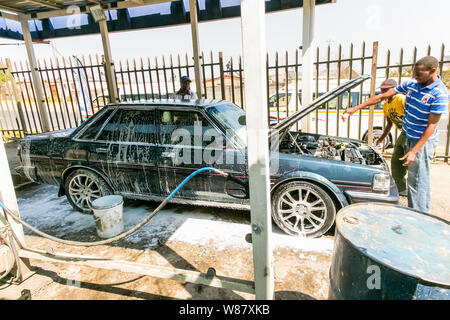 Johannesburg, Südafrika - 29. August 2013: afrikanischer Mann ein Auto waschen in einer Suburbanen Gemeinde carwash Depot Stockfoto