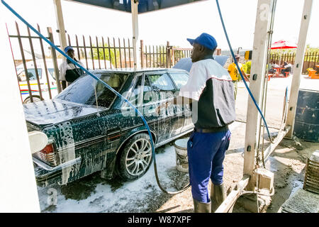 Johannesburg, Südafrika - 29. August 2013: afrikanischer Mann ein Auto waschen in einer Suburbanen Gemeinde carwash Depot Stockfoto