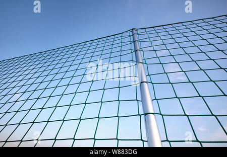 Eine silberne Stange mit einem Netz Gebäude einen Zaun gegen die blauen Abendhimmel Stockfoto