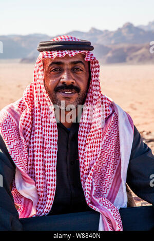 Ein Beduinen-Mann sitzt vor dem Hintergrund der jordanischen Wüste Wadi Rum oder Tal des Mondes Stockfoto