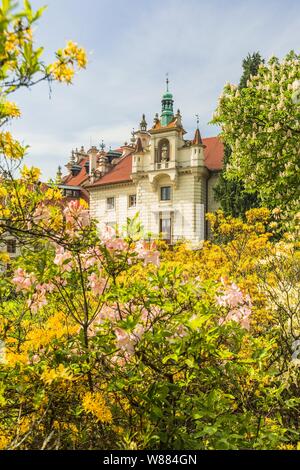 Prag/Tschechische Republik - 19. Mai 2019: Frühling Blick auf die romantische Burg in einem Garten mit Bäumen und bunten Blüten im Vordergrund. Sonnigen Tag. Stockfoto