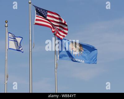 Flaggen der Usa, Oklahoma State und wenig Ax Schule in Oklahoma fliegen von ihren Polen Stockfoto