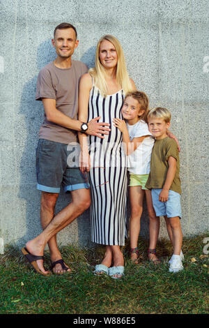 Bild von Familie mit Kindern in der Nähe von betonwand auf der Straße Stockfoto