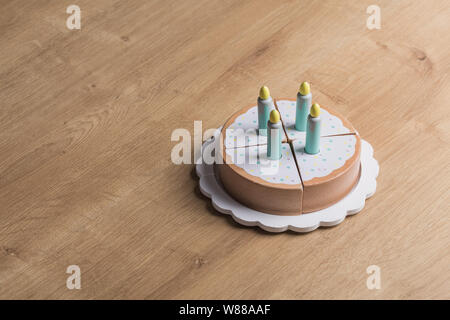 Spielzeug aus Holz Geburtstag Kuchen mit Kerzen auf einem hölzernen Hintergrund Stockfoto