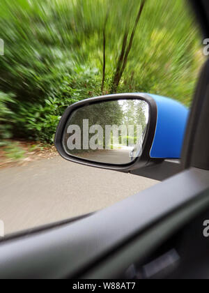Außenspiegel Reflexion der Zweispurige kurvenreiche Straße in Wald, schöne grüne Natur Stockfoto