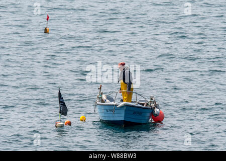 Fischer in kleines Fischerboot Drop/schießen Hummerfallen/Hummer pots/hummer Reusen im Atlantischen Ozean/Englischen Kanal Stockfoto