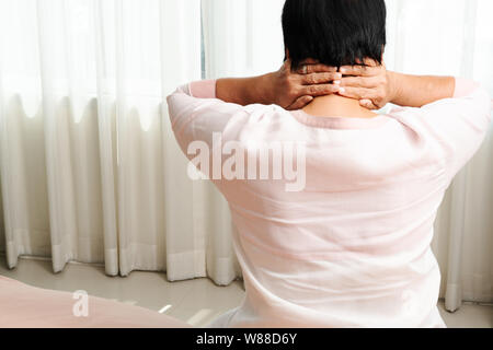 Nacken- und Schulterschmerzen, eine alte Frau mit Hals und Schulter Verletzung, gesundheitliche Problem Konzept Stockfoto