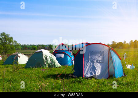 Touristische Zelte auf der Lichtung. Ein Platz zum Camping auf einer Wiese in der Natur im Sommer. Stockfoto