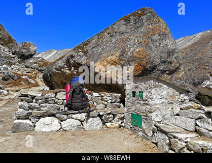 Ruhestätte aus Stein in der Nähe der Behälter für das Recycling Materialien auf der Trekkingroute zum Everest Höhepunkt im Himalaya, Nepal. Die Natur cl Stockfoto