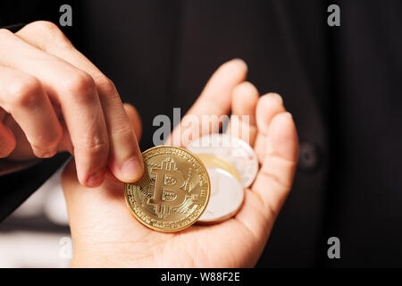 Cryptocurrency Bitcoin. Frauen halten die cryptocurrency Münze in der Hand. Physische bitcoins Goldmünze Stockfoto
