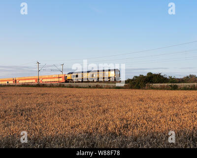 GBRF Class 66 Lokomotive 66716 schleppt die Garston Auto Terminal Dagenham Docks Rezeption südlich von Northampton, wie die Sonne. Stockfoto