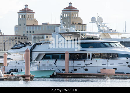 Weiß superyacht in Palm Harbor Marina am Wasser in der Innenstadt von West Palm Beach mit dem Palm Beach Biltmore im Hintergrund. (USA) Stockfoto