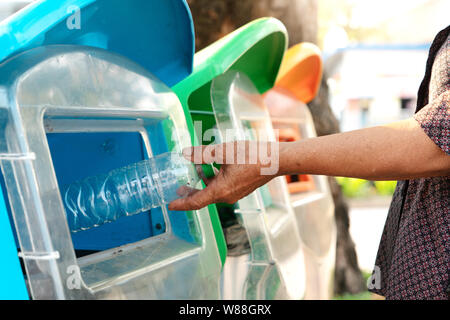 Alte Frauen geben den Müll in den Müll/Müll und sortieren Abfall/Müll vor dem Tropfen in den Müll Stockfoto
