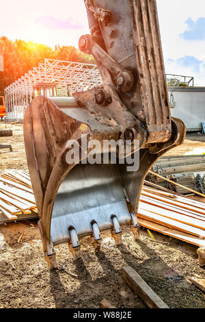 Der Eimer des Baggers liegt auf dem Boden, vom Bagger entfernt. Stockfoto