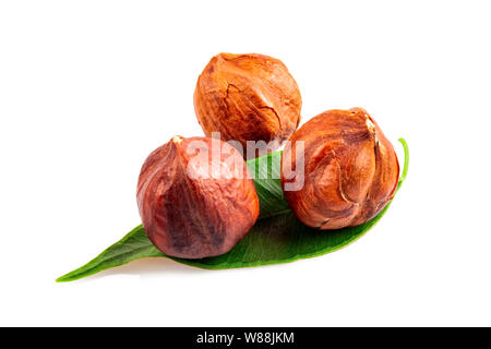 Geröstete Nüsse mit grünem Blatt auf weißem Hintergrund Stockfoto