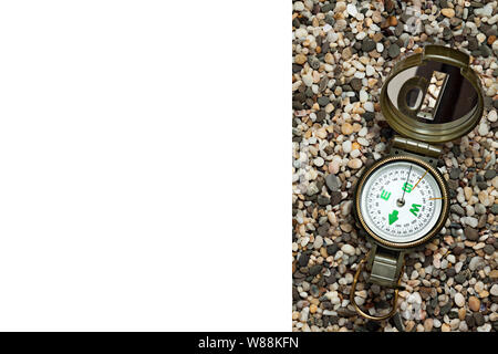 Der Kompass liegt auf einem kleinen Stein, Nahaufnahme. Es gibt einen Platz für die Inschrift. Stockfoto