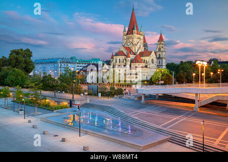 Wien, Österreich. Stadtbild Bild von Wien, Hauptstadt von Österreich mit dem Hl. Franz von Assisi Kirche während der schönen Sonnenuntergang. Stockfoto