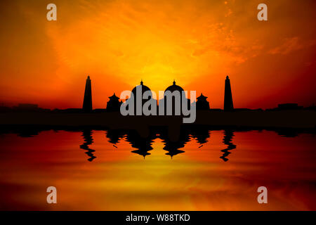 Silhoutte Bild der Sonnenuntergang über einer Moschee mit Wasser Reflexion Stockfoto