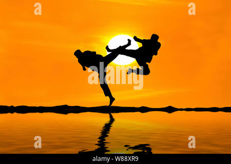 Kampf gegen einen Feind in der Nähe des Strandes, wenn die Sonne untergeht Stockfoto