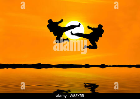 Kampf gegen einen Feind in der Nähe des Strandes, wenn die Sonne untergeht Stockfoto