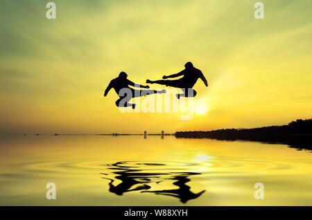 Kampf gegen einen Feind in der Nähe des Strandes, wenn die Sonne untergeht Stockfoto