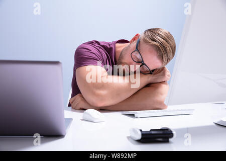 Erschöpft, Geschäftsmann, Schlafen auf dem Schreibtisch vor dem Computer im Büro Stockfoto