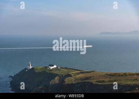 Kreuzfahrtschiff vorbei Leuchtturm in der Nähe von Howth Summit, Dublin, Irland Stockfoto