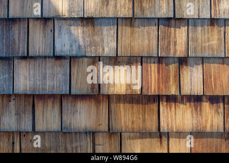 Grobe holprigen Holz Schindel Verkleidungen, Zeile aus Holz kleiner Dachschindel Fassade. Stockfoto