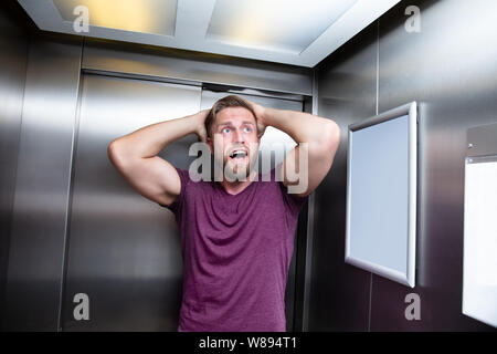 Man Platzangst Leiden gefangen im Aufzug Schreien Stockfoto