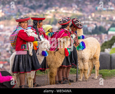 Cuzco, Peru - Mai 3, 2019. Peruanische Frauen und Babys mit traditioneller Kleidung mit Alpakas Stockfoto