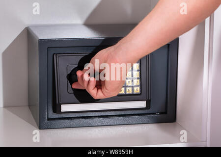 Eines Mannes Hand öffnen Safe Stockfoto