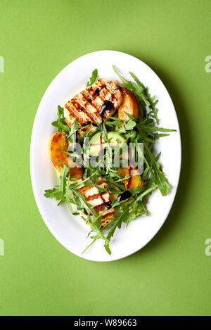 Salat mit gegrilltem Halloumi gebraten und Pfirsiche. top View Stockfoto