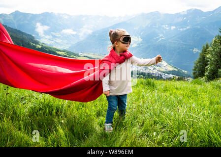 Kleine Mädchen spielen Superheldenspiel in Berg Stockfoto