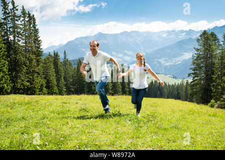 Paar Hände halten, die auf Feld, in den Bergen Stockfoto