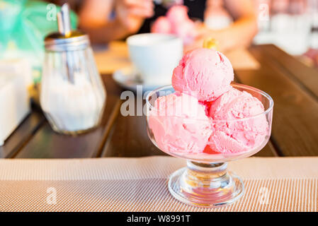 Schließen Sie bis zu drei Kugeln Erdbeereis in Glasschale Stockfoto