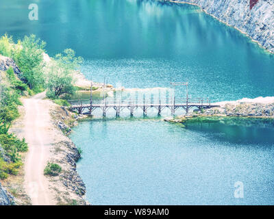 Tiefe Grand Canyon mit blauen See am unteren Rand. Viele Straßen und an der kleinen Brücke in der Mitte Stockfoto