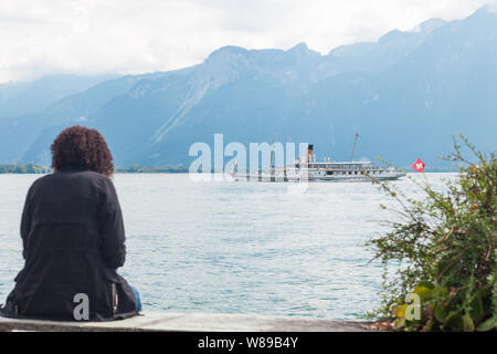 Frau sitzt am Montreux Promenade und genießen Sie die Aussicht auf den Genfersee (Lac Leman) und traditionelle Paddle steamboat Montreux Kreuzfahrt entlang Schweizer Ufer Stockfoto