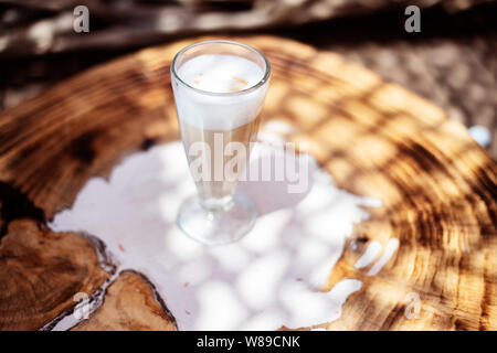 Kaffee Cafe Latte macchiato draußen auf einem rustikalen Holztisch Stockfoto