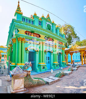 MONYWA, MYANMAR - 22. FEBRUAR 2018: Die grünen Tempel der Thanboddhay Kloster mit Relief Muster, Säulen und Skulpturen von Naga Schlange vor Stockfoto
