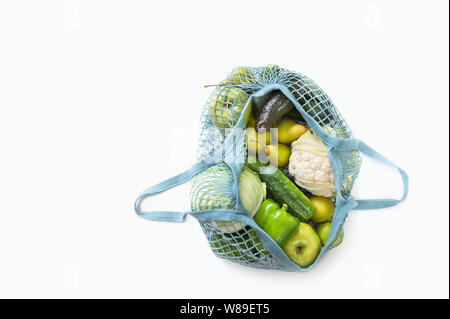 Blick von oben auf die mesh Einkaufstasche mit organischen eco Gemüse auf weißem Hintergrund. Detox und gesunde Ernährung Konzept. Vegetarisches Essen. Null Abfall. Stockfoto